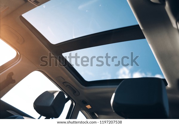 Panoramic glass sun roof in the car. Clean glass and\
view from inside to the\
sky
