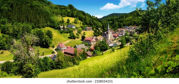 Panoramic gorgeous landscape containing an idyllic German village in a lush green valley in the Black Forest