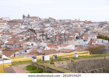 Panoramic high-angle view of the historic white houses and terracotta roofs in the garrison border town of Elvas, looking over the medieval fortification walls and bastions, Alentejo region, Portugal.