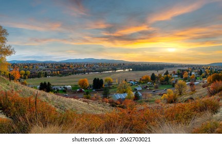 Panoramic hillside view over rural Spokane Valley looking towards downtown Spokane, Washington, as the sun sets on an Autumn day with fall colors.