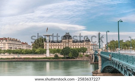 Panoramic hyperlapse view of the Rhone River and its embankment, featuring the University Jean-Moulin in Lyon, France. Includes the University Bridge and waterfront under a partly cloudy sky timelapse