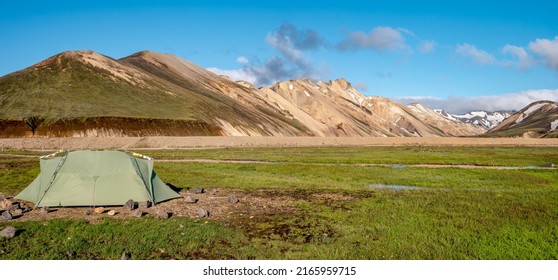 Panoramic Icelandic Landscape Of Colorful Rainbow Volcanic Landmannalaugar Mountains, And A Lonely Green Tent At The Camping Site With No People, Iceland, Summer At Blue Sky