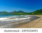 Panoramic image of Bonete beach in Ilhabela with the sea, hills and forests surrounding it