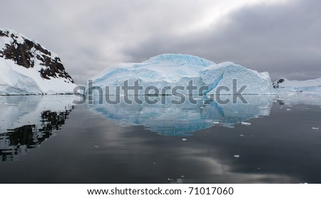 A panoramic image of an iceberg and its reflexion
