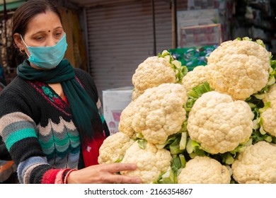 Panoramic Image Of Indian Mature Woman Wearing Protective Face Mask And Buying Fresh Green Vegetables From Outdoor Market During The Third Wave Of Coronavirus, COVID-19 Pandemic Outbreak In Indian.