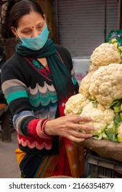 Panoramic Image Of Indian Mature Woman Wearing Protective Face Mask And Buying Fresh Green Vegetables From Outdoor Market During The Third Wave Of Coronavirus, COVID-19 Pandemic Outbreak In Indian.