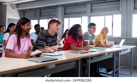 Panoramic image of multiracial happy, smiling college students in classroom listening to lecture. High school students in class. Education concept. - Powered by Shutterstock