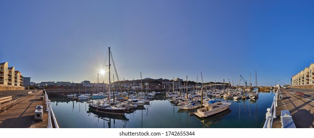 Panoramic image of St Helier Marina early morning from the West marina wall with the visitor births on the left hand side and the entrance on the right hand side. Jersey, Channel Islands
