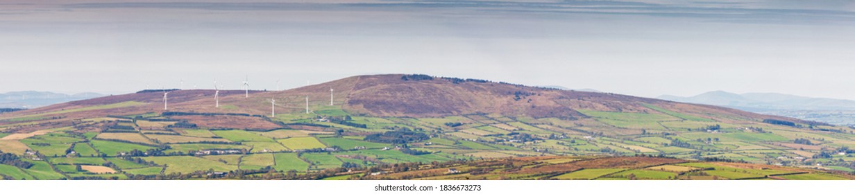 A panoramic landcape sview of the fields with wind turbines. Alternative energy concept.