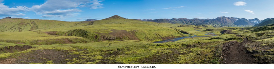 Panoramic landscape with blue river stream, green hills, snow-capped mountains, meadow and lush moss. Laugavegur hiking trail. with Fjallabak Nature Reserve, Iceland. Summer blue sky - Powered by Shutterstock