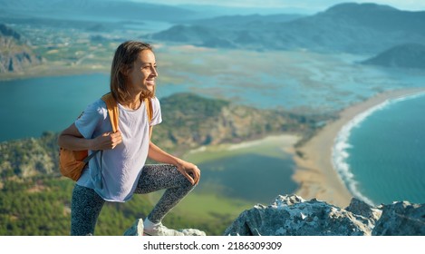 Panoramic Landscape Of Coastal Sea Bay With Mountains Range. Hiker Girl On Top Of Mountain Admiring Nature Epic Scene