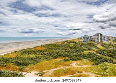 Panoramic landscape of dunes, beach, North Sea and high-rise buildings against stormy sky covered with clouds in tourist village De Panne, horizon in background, cloudy day in West Flanders, Belgium - Powered by Shutterstock