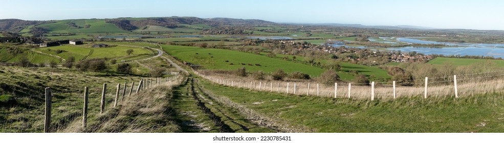 Panoramic landscape with fences leading towards Bury Hill, South Downs National Park, West Sussex. . Fields next to the River Arun are flooded as they run through Amberley Wild Brooks. Copy space. - Shutterstock ID 2230785431