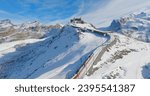 Panoramic landscape of Gornergrat bahn railway climibing up the summit station with Matterhorn mountain peak background in Zermatt on a sunny winter day. Swiss Alps, Switzerland travel journey trip.