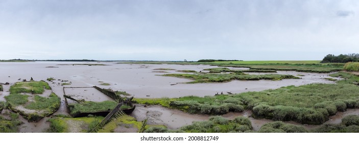 panoramic landscape image of an old abandoned boat on the mud banks of maldon in essex england