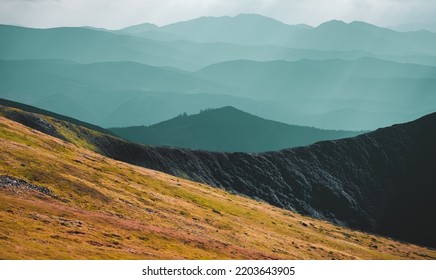 Panoramic Landscape Of Mountain Range In Autumn Morning. Orange Grass Hill Slope, Blue Highlands Silhouette, Mountain Peak Top. Travel, Hiking, Freedom, Active Lifestyle. Carpathian Mountains, Ukraine