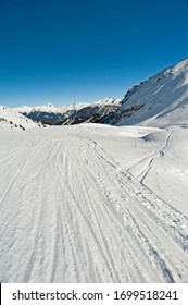 Panoramic landscape valley view down a ski slope piste in winter alpine mountain resort