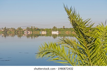 Panoramic Landscape View Across Nile River To Luxor West Bank With Mountains And Reflection In Water