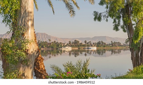 Panoramic Landscape View Across Nile River To Luxor West Bank With Mountains And Reflection In Water