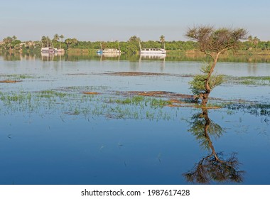 Panoramic Landscape View Across Nile River To Luxor West Bank With Mountains And Reflection In Water