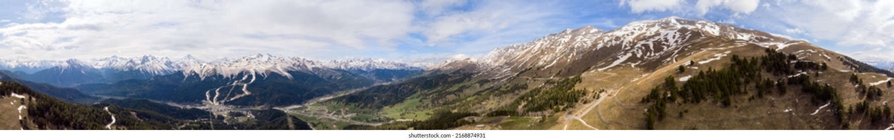 Panoramic landscape view, snow covered mountain peaks on mountain range. Hills and mountains covered with green pine forest. Arkhyz ski resort, Caucasus mountains, Russia