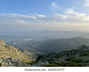 Panoramic mountain view under a cloudy blue sky.