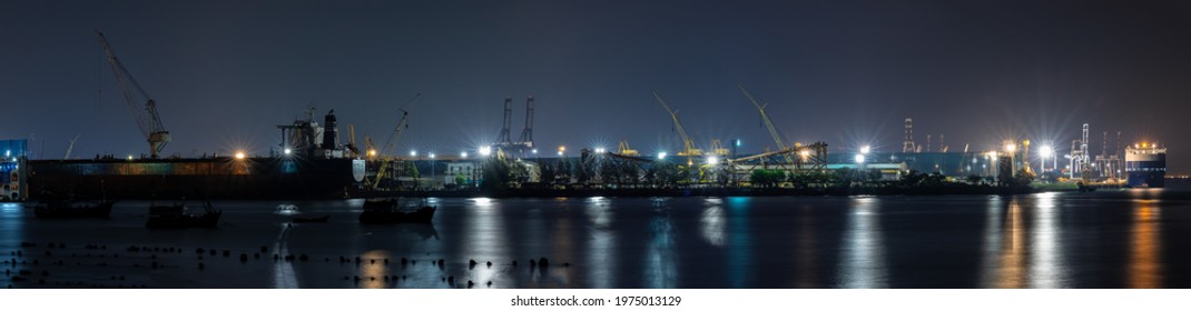 Panoramic Night Scene And Long Exposure Shot Container Oil Ship Repair In Shipyard Can Use For Shipping Or Transportation Concept.
