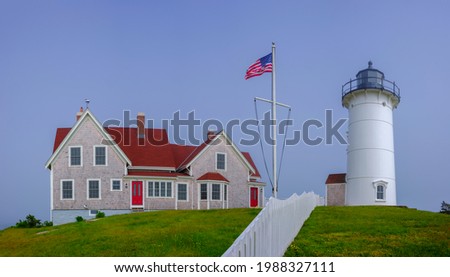 Panoramic Nobska Lighthouse and Red Roof House Landscape in Woods Hole on Cape Cod, Massachusetts. Lighthouse with American Flag.