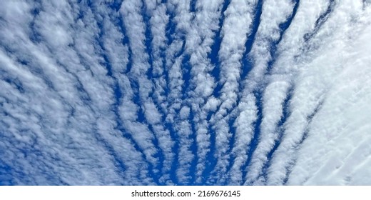 Panoramic pattern of white clouds up in a blue sky