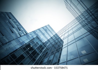 Panoramic And Perspective Wide Angle View To Steel Blue Background Of Glass High Rise Building Skyscrapers In Modern Futuristic Downtown At Night Business Concept Of Successful Industrial Architecture