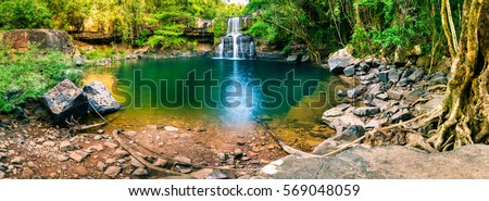 Panoramic photo landscape / Waterfall hidden in the tropical jungle surrounded by a natural swimming pool with clear fresh water on background green forest tree and mountain / Asia