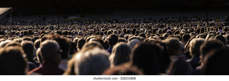 Panoramic photo of large crowd of people. Slow shutter speed motion blur.