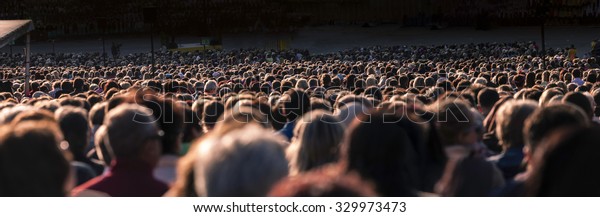 Panoramic photo of large crowd of people. Slow\
shutter speed motion\
blur.