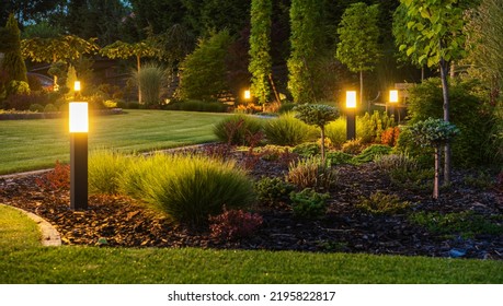 Foto Panorámica de Puestos de Luz LED Jardín trasero Iluminado durante Horas Nocturnas. Modernos sistemas de iluminación exterior en el patio trasero.