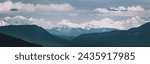 Panoramic photograph of the Pyrenees in winter. Snow-capped peaks with clouds on the horizon. View of the mountain range from Navarra, Spain. Roncal Valley.