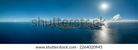 Panoramic picture of the island of Martinique, with the town of Anse d'Arlet in the center, grande anse beach on the left side, and the diamond rock on the right side.