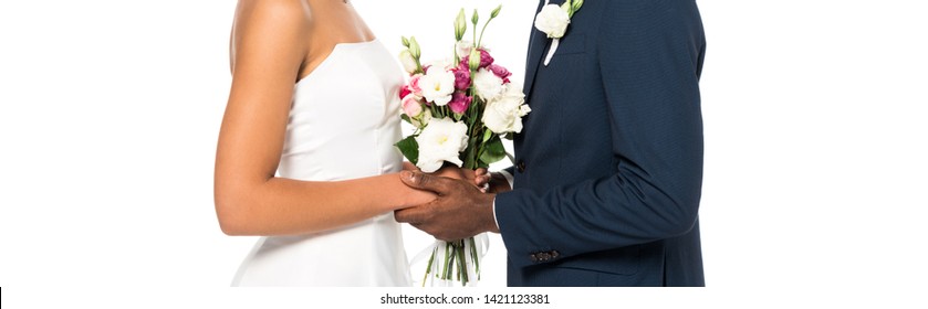 panoramic shot of african american bride and bridegroom holding bouquet isolated on white