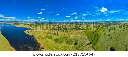 A panoramic shot of a big green field at Rangers Vally Cattle with beautiful blue sky in Australia with a river next to it Stock photo © 