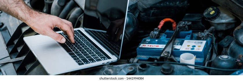 panoramic shot of car mechanic using laptop with blank screen near car  - Powered by Shutterstock