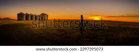 A panoramic shot of grain silos in Montana during the sunset