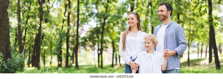 Panoramic Shot Of Happy Family Holding Hands In Park With Copy Space