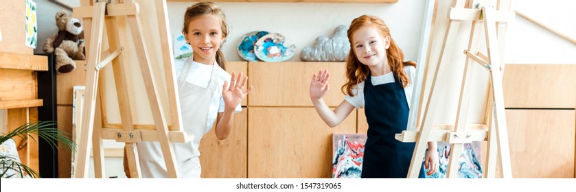 Panoramic Shot Of Happy Kids Waving Hands In Art School 