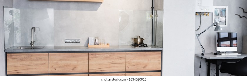 Panoramic shot of minimalistic kitchen and workplace with computer - Powered by Shutterstock