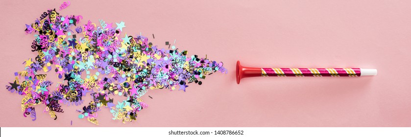 Panoramic Shot Of Party Horn With Sparkling Confetti On Pink Background