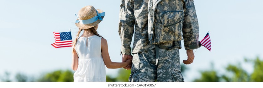 Panoramic Shot Of Patriotic Child And Man In Military Uniform Holding Hands And American Flags 