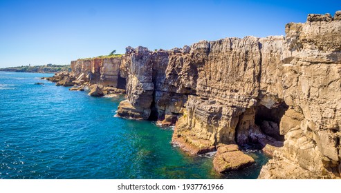 A panoramic shot of the rocks beside the ocean in Cascais, Portugal