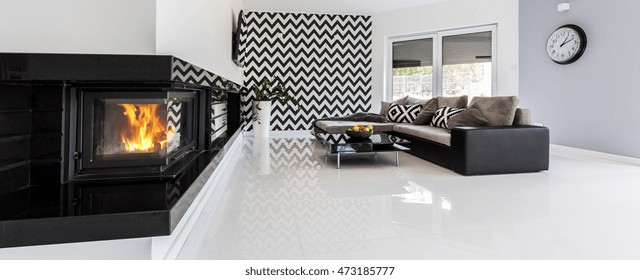 Panoramic shot of a stylish living room interior with a wall with black and white pattern