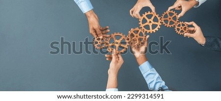 Panoramic shot top view of business people holding cog wheel as unity and teamwork in corporate workplace concept. Office worker colleague with symbol of visionary system for business success. Concord