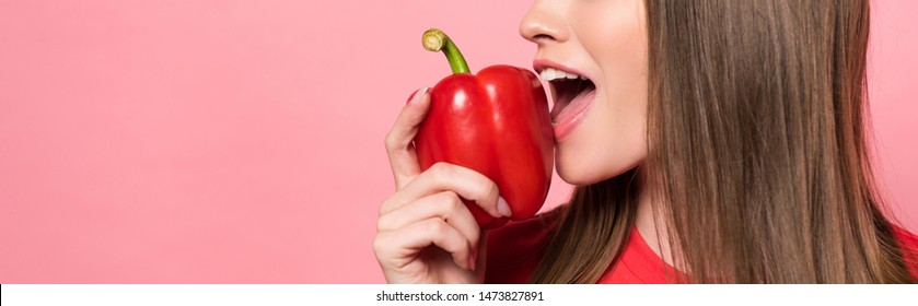 Panoramic Shot Of Young Woman Eating Red Bell Pepper Isolated On Pink