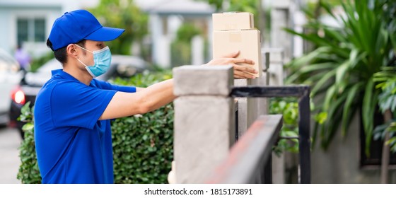 Panoramic Side View Asian Deliver Man With Face Mask In Blue Shirt Handling Packages And Put In On The Fence Post As Contactless Shopping Delivery. This Can Reduce Coronavirus COVID-19 Spreading.